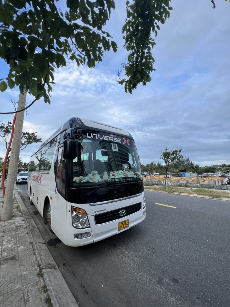 Tour bus parked on roadside, Nhà thờ Đức Mẹ Sao Biển, Đà Nẵng, Vietnam.